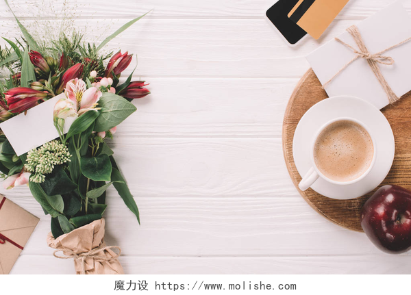 有着鲜花和咖啡的条纹木制背景平躺在白色木桌上裹着鲜花, 杯咖啡和信用卡